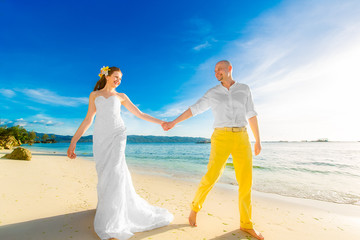 bride and groom on a tropical beach with the sunset 