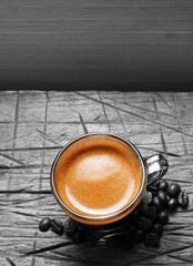 Cup of hot espresso coffee and coffee crop on wood board