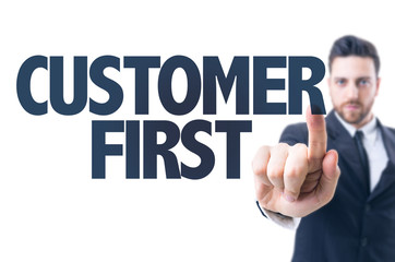 Business man pointing the text: Customer First