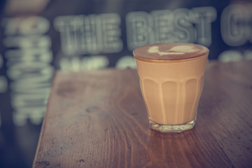 coffee latte cup on a wood table -vintage effect style pictures