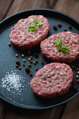 Raw cutlets made of ground beef with spices, close-up