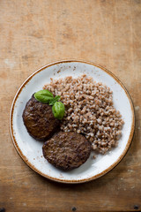 Meat cutlets with buckwheat on a rustic wooden surface