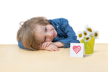 Adorable little boy with daisy bouquet and a red heart card 