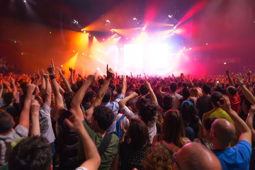 crowd of people at concert in front of the stage with lights