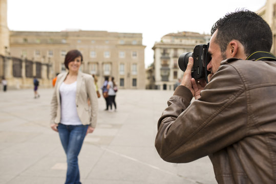 Man taking picture of attractive woman in public place