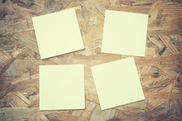 four yellow blank note paper on plywood