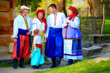 happy ukrainian family in traditional costumes on homestead