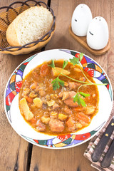 Pork stew in plate on wooden table
