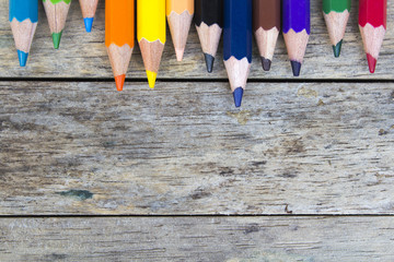 color pencils on wood plank, top view