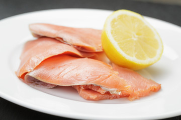 rolls of sliced smoked salmon on slate board