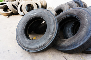 Tires stacked near cement wall, used tires