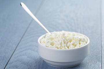 cottage cheese in white bowl on blue wooden table