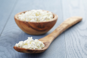 cottage cheese in wood bowl on blue wooden table