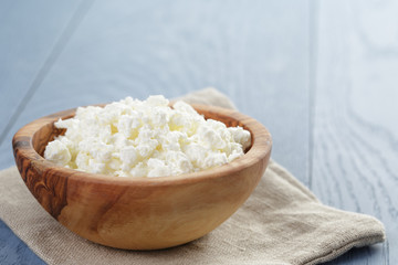 cottage cheese in wood bowl on blue wooden table