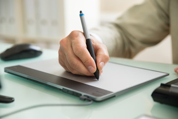Businessman Writing On Graphic Tablet
