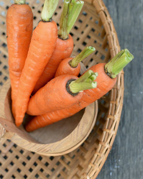 Fresh Organic Carrots in a basket on wooden background