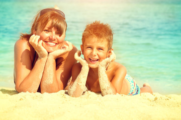 Mother and son lying at the beach. Travel and vacation