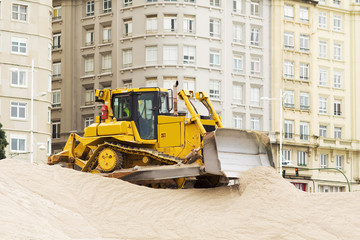 yellows excavators on the city  beach working sand moving