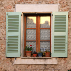 rustic window with wood shutters in stone rural house, Provence