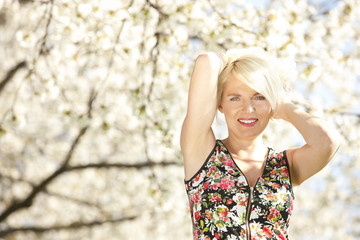 Hübsche blonde Frau vor blühendem Frühlings Baum