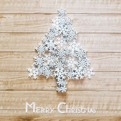 New Year tree made of plastic snowflakes on wooden 