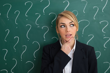 Thoughtful Businesswoman In Front Of Chalkboard