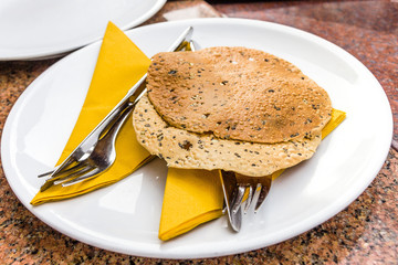  Indian bread on a white plate with cutlery