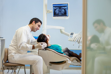dentist is taking a plaster model from a young asian patient