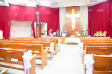 Blurred interior of empty church with empty pews