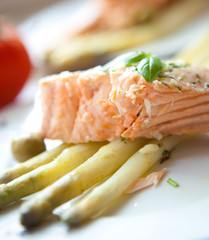 Grilled salmon with asparagus on white plate
