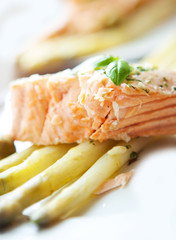 Grilled salmon with asparagus on white plate