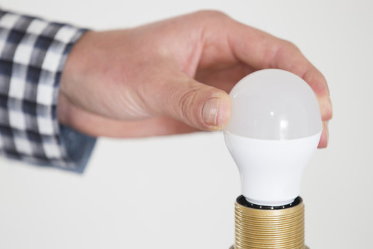 Hand Adjusting Electric Bulb At Home