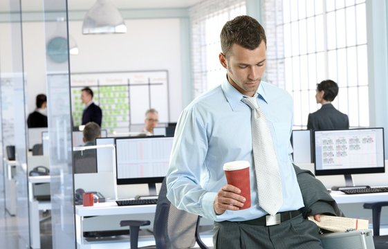 Businessman arriving to office holding coffee