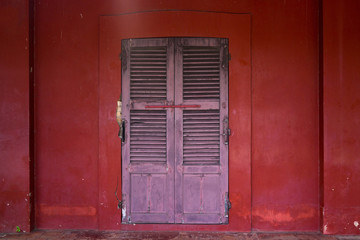Old wooden door on the red wall