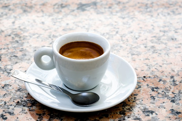 White espresso cup standing on the marble table