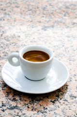 White espresso cup standing on the marble table
