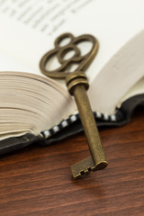 Antique key on opened book page
