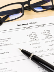 Balance sheet financial report with pen, and glasses; document i