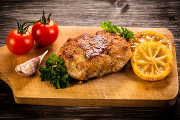 Fried chops and vegetables on cutting board 