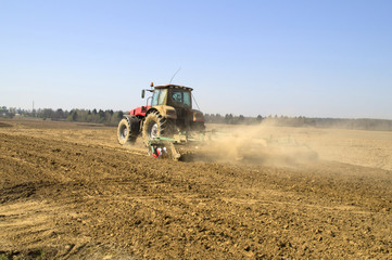 Modern power tractor wheels the soil before planting