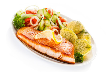 Fried salmon and vegetables on white background