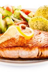 Fried salmon and vegetables on white background
