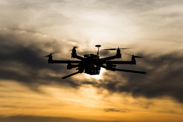 Professional drone flying in the cloudy sunset