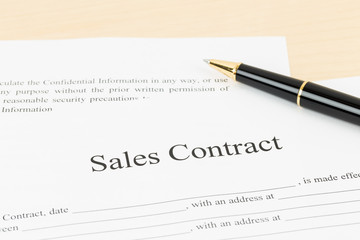Sales contract document with pen, document is mock-up
