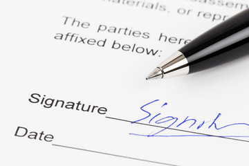 Obraz premium Signature on document with pen, signature is mock-up