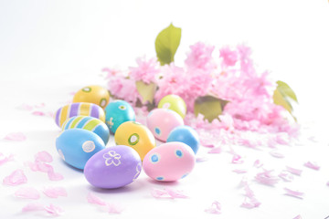Bright Easter eggs with pink flowers on white background