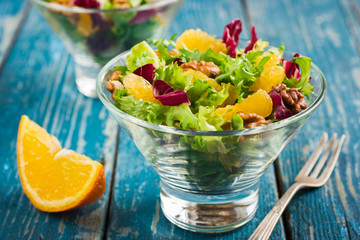Healthy salad mix with orange and walnuts in glass