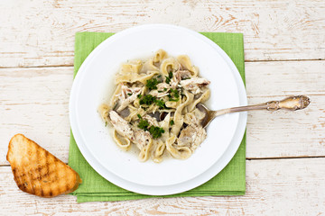 A bowl of soup with noodles and chicken 