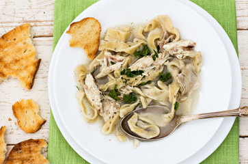 A bowl of soup with noodles and chicken 