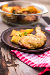 Baked chicken pieces with potatoes, herbs and garlic 